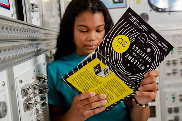 girl looking at the pages of a book