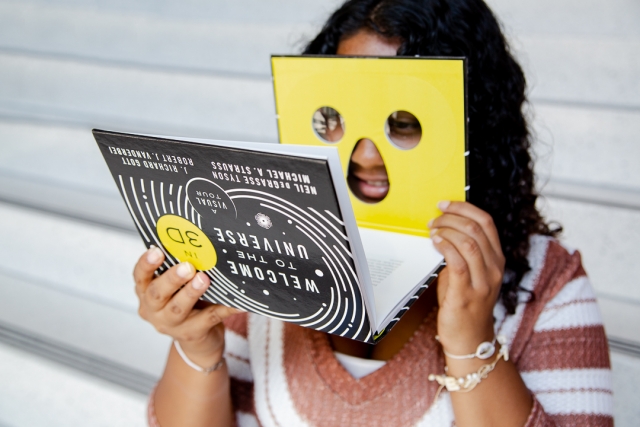 girl looking through 3D viewer on book