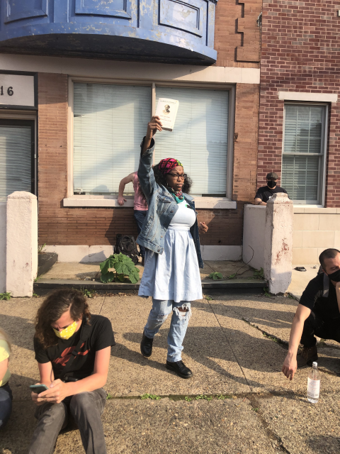 Jeannine Cook on sidewalk holding book